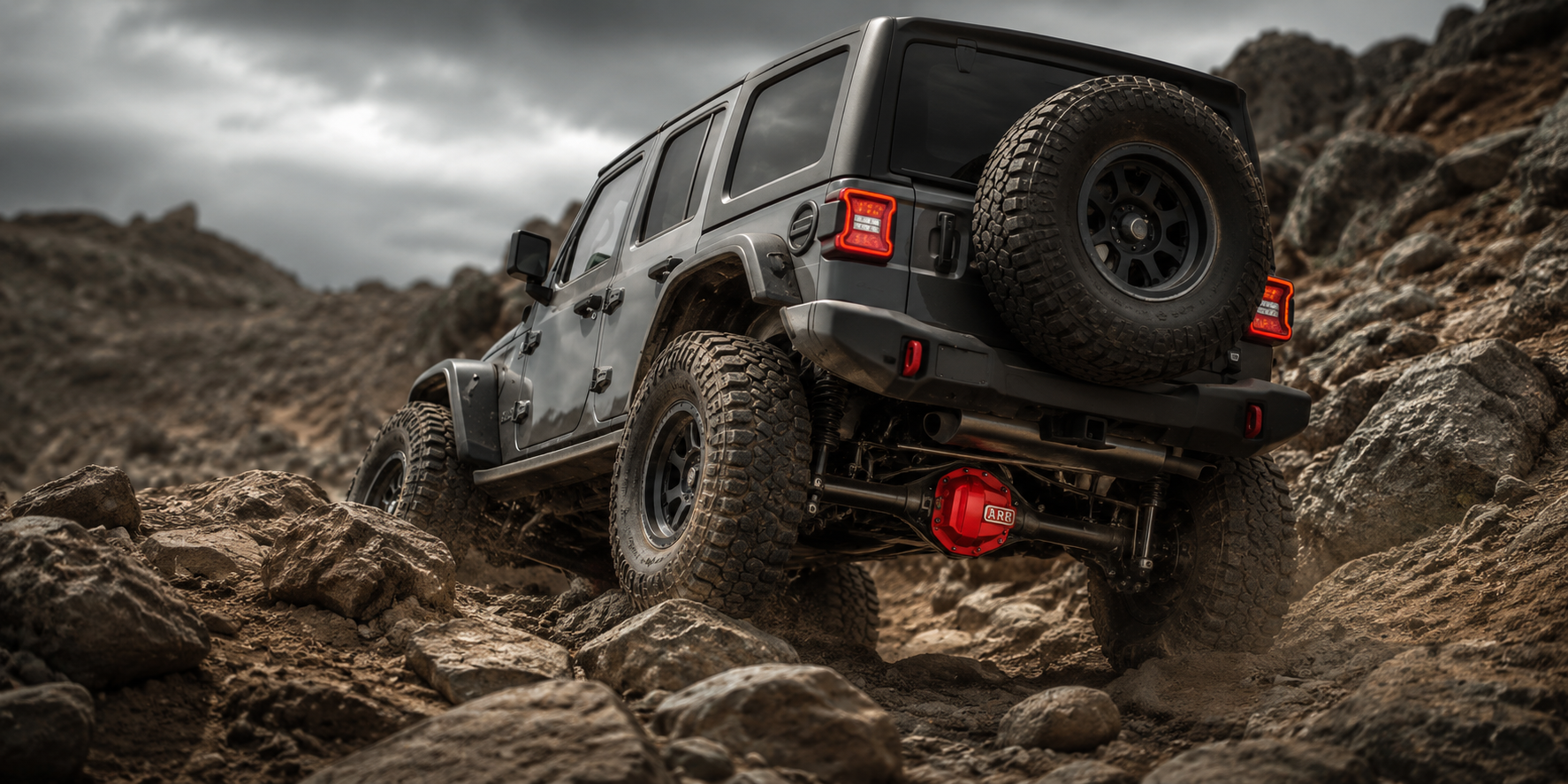 Off-road truck climbing rocky terrain with ARB style differential locker components and rugged Elite Offroad lighting