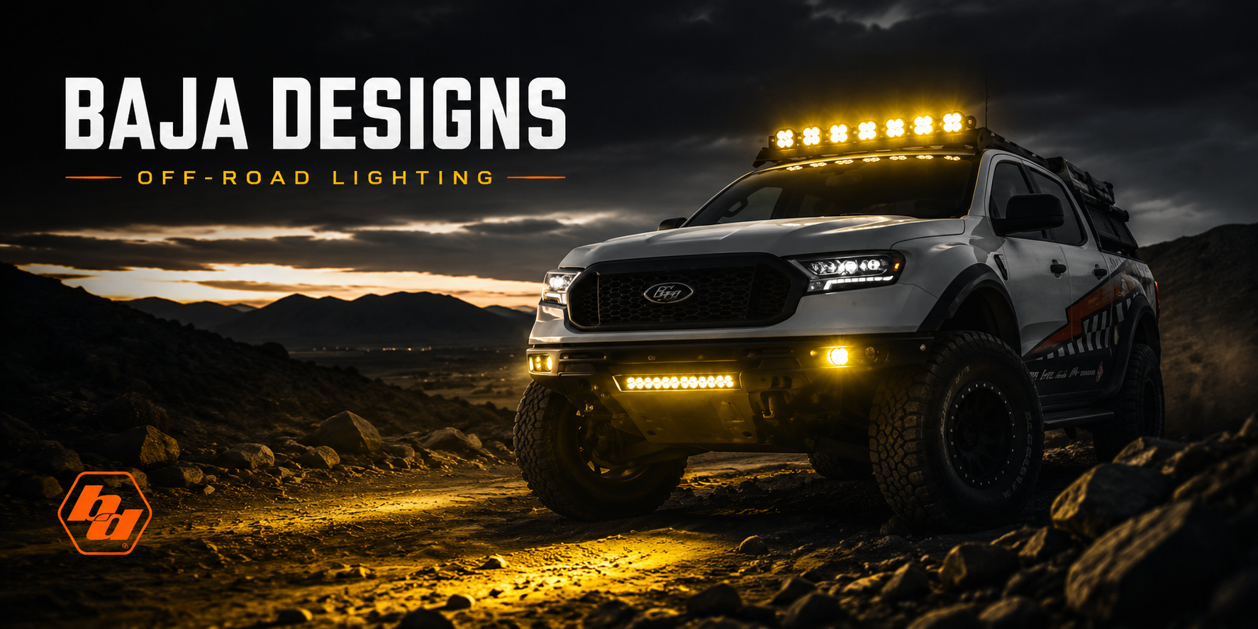 Off-road truck on a dark trail with Baja Designs style LED lights, amber fog lights, and orange Elite Offroad lighting theme