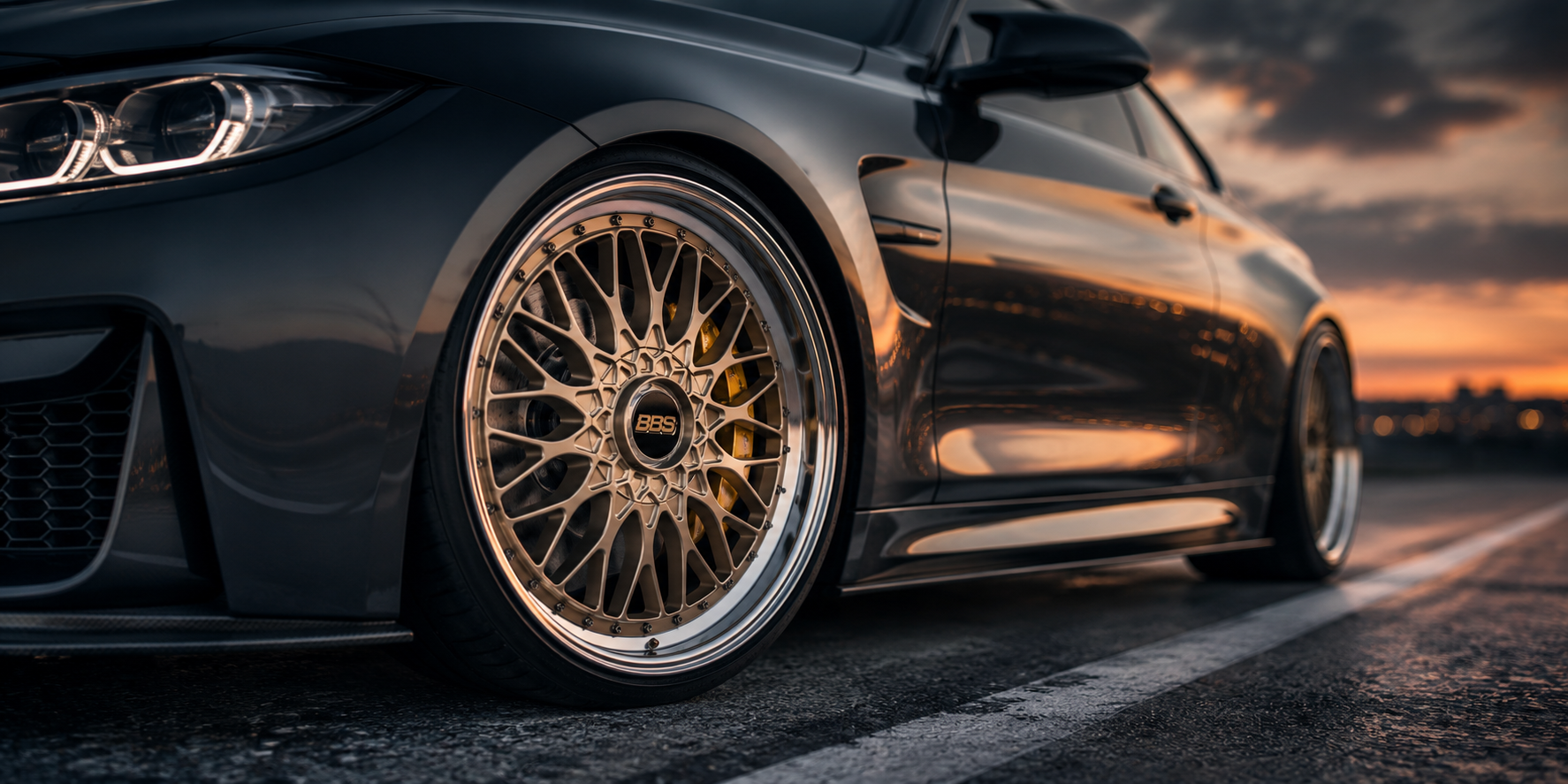 Performance coupe with BBS style wheels in a dark cinematic garage showing motorsport-inspired fitment and premium wheel styling